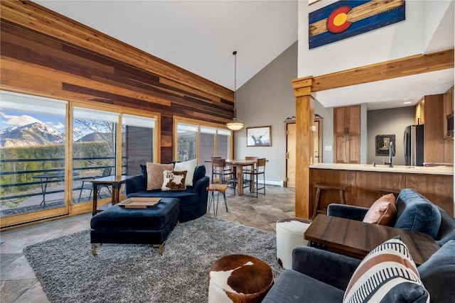 91200 Ryan Gulch Rd Unit 91222, Silverthorne, CO 80498 - living room featuring high vaulted ceiling, wood walls, stone finish flooring, and baseboards