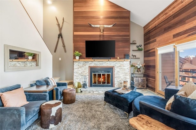 91200 Ryan Gulch Rd Unit 91222, Silverthorne, CO 80498 - living room featuring wood walls, high vaulted ceiling, a stone fireplace, and carpet flooring