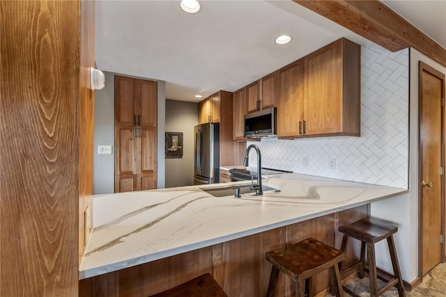 91200 Ryan Gulch Rd Unit 91222, Silverthorne, CO 80498 - kitchen featuring stainless steel appliances, recessed lighting, light stone counters, a peninsula, and a kitchen breakfast bar