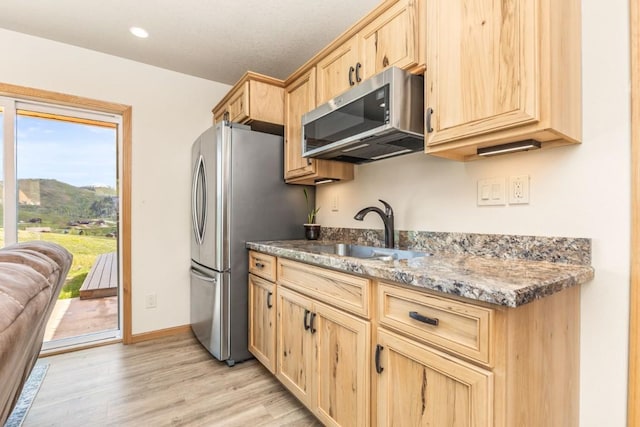 26870 Beaver Canyon Dr, Clark, CO 80428 - kitchen with stainless steel appliances, light brown cabinetry, a sink, light wood finished floors, and recessed lighting