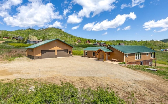 26870 Beaver Canyon Dr, Clark, CO 80428 - view of front facade featuring a garage, an outdoor structure, metal roof, and a mountain view