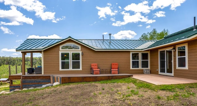26870 Beaver Canyon Dr, Clark, CO 80428 - back of property featuring a standing seam roof, a patio, metal roof, and a deck