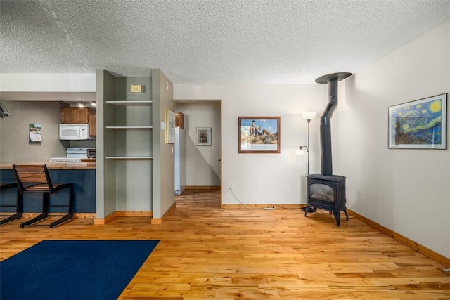 3 Cypress Ct Unit 3, Steamboat Springs, CO 80487 - interior space featuring a textured ceiling, baseboards, light wood-style flooring, and a wood stove