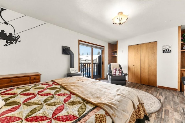 1149 Overlook Dr Unit C3, Steamboat Springs, CO 80487 - bedroom featuring wood finished floors, a wood stove, a closet, baseboards, and access to outside