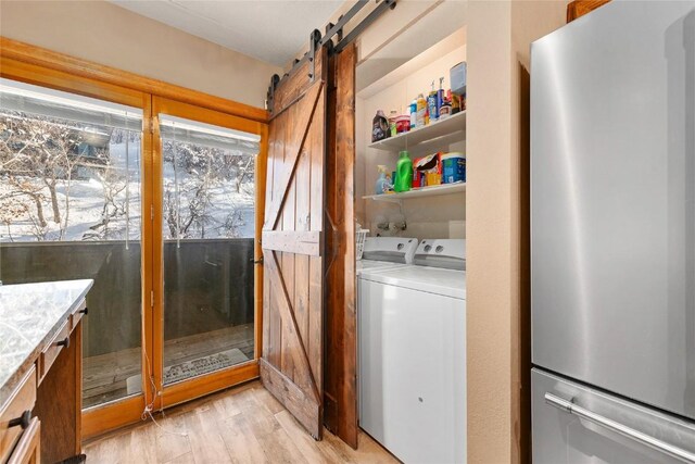 1149 Overlook Dr Unit C3, Steamboat Springs, CO 80487 - laundry area with a barn door, light wood finished floors, laundry area, and independent washer and dryer