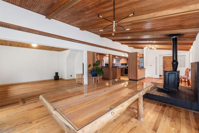 50035 Moon Hill Dr, Steamboat Springs, CO 80487 - dining space with a chandelier, light wood-style floors, a wood stove, and a wooden ceiling with exposed beams