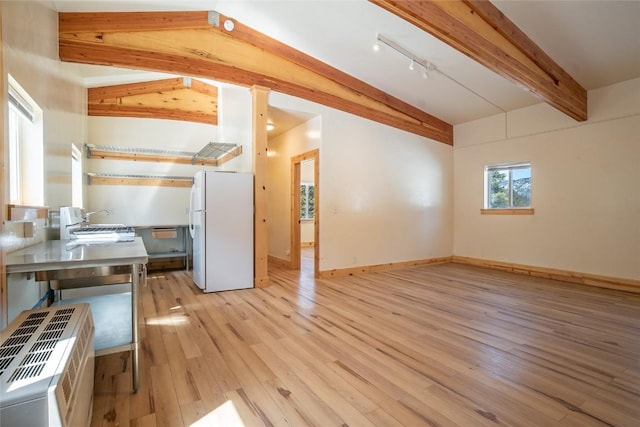 5277 Montezuma Rd, Montezuma, CO 80435 - interior space featuring rail lighting, baseboards, vaulted ceiling with beams, and light wood-type flooring