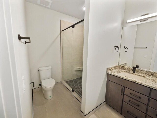 bathroom featuring a shower stall, toilet, tile patterned floors, and vanity
