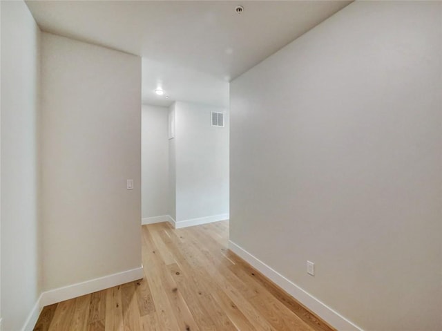 empty room with baseboards and light wood-style floors
