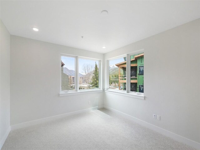 carpeted spare room featuring baseboards and recessed lighting