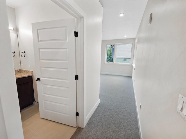 corridor with baseboards, light colored carpet, and recessed lighting