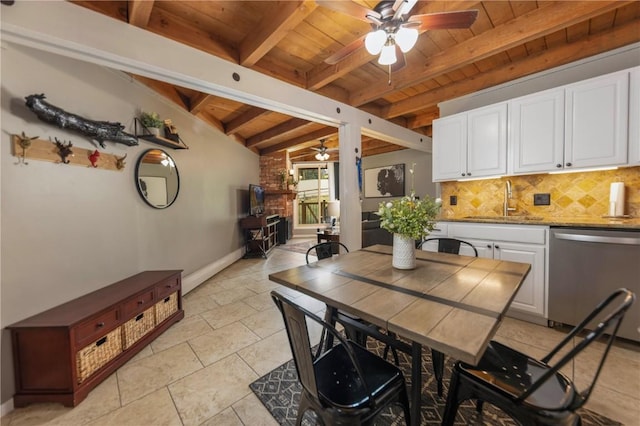 dining space featuring baseboards, vaulted ceiling with beams, wooden ceiling, and ceiling fan