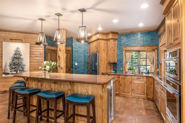486 Sage Creek Canyon Dr, Silverthorne, CO 80498 - kitchen with appliances with stainless steel finishes, a kitchen island, beverage cooler, stone counters, and a kitchen bar
