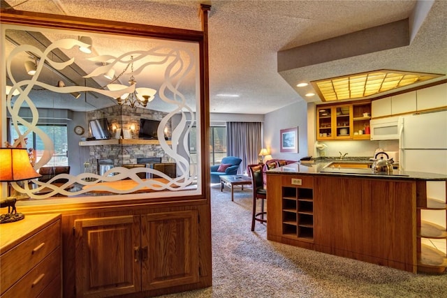 kitchen featuring carpet flooring, a textured ceiling, open floor plan, white appliances, and open shelves