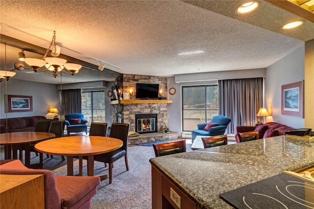 living room featuring plenty of natural light, a fireplace, carpet floors, and a textured ceiling