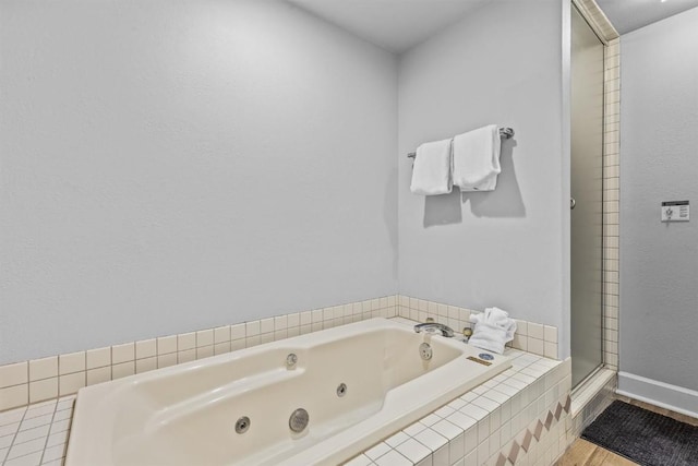 1724 Ski Time Square Dr Unit R6, Steamboat Springs, CO 80487 - bathroom featuring a tub with jets, a stall shower, baseboards, and wood finished floors