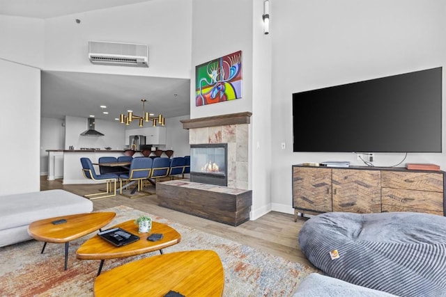 1724 Ski Time Square Dr Unit R6, Steamboat Springs, CO 80487 - living area with a high ceiling, wood finished floors, baseboards, a tile fireplace, and an AC wall unit