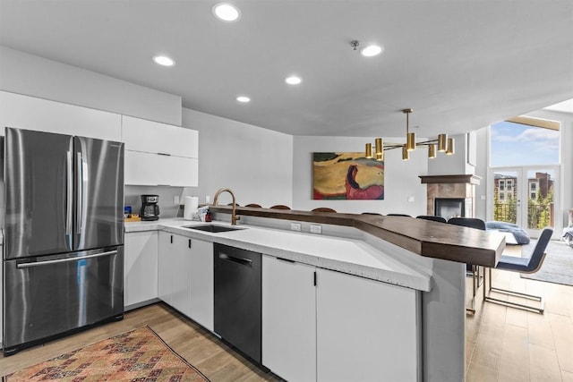 1724 Ski Time Square Dr Unit R6, Steamboat Springs, CO 80487 - kitchen featuring freestanding refrigerator, a sink, open floor plan, dishwashing machine, and a peninsula