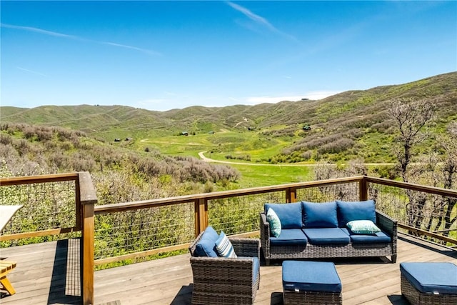 wooden terrace featuring a mountain view and an outdoor hangout area