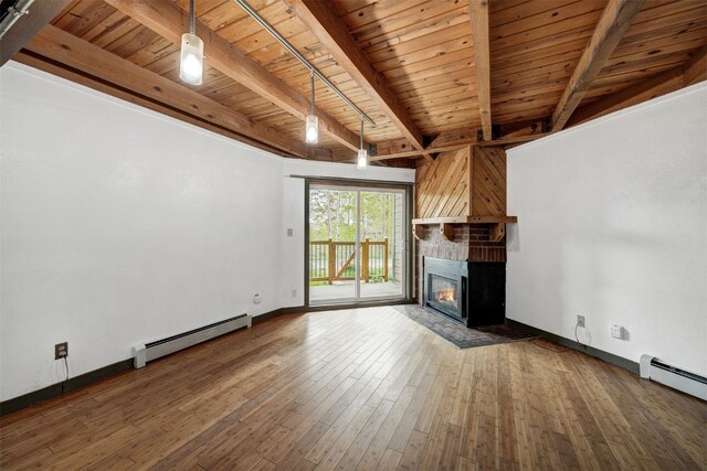 8500 Ryan Gulch Rd Unit G2, Wildernest, CO 80498 - unfurnished living room with a baseboard radiator, wooden ceiling with exposed beams, a glass covered fireplace, baseboards, and hardwood / wood-style floors