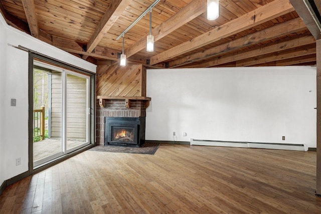 8500 Ryan Gulch Rd Unit G2, Wildernest, CO 80498 - unfurnished living room with wood ceiling with exposed beams, a brick fireplace, baseboards, a baseboard heating unit, and hardwood / wood-style floors