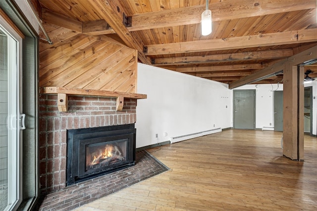 8500 Ryan Gulch Rd Unit G2, Wildernest, CO 80498 - unfurnished living room with a baseboard heating unit, a fireplace, wooden ceiling with exposed beams, and hardwood / wood-style flooring