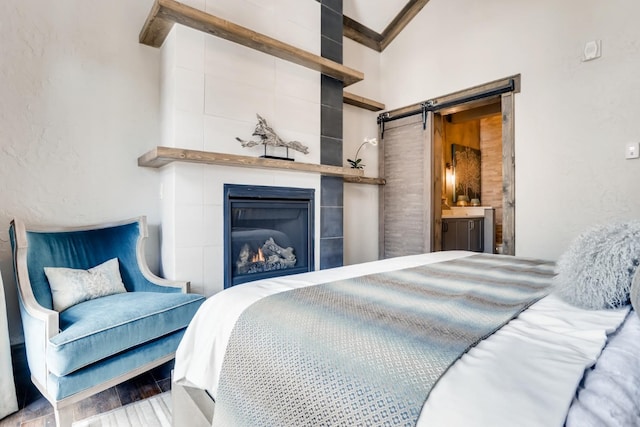 0117 Lake Ridge Cir Unit 1864, Keystone, CO 80435 - bedroom featuring ensuite bath, wood finished floors, a large fireplace, and a barn door