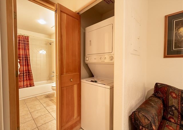 23110 US Highway 6 Unit 319, Keystone, CO 80435 - laundry area with stacked washer / dryer and light tile patterned flooring