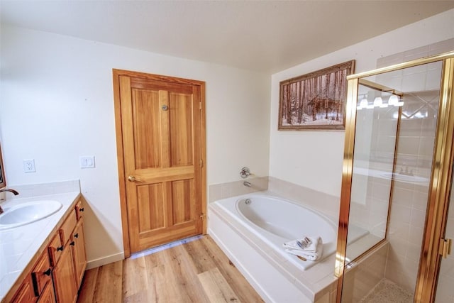 23110 US Highway 6 Unit 319, Keystone, CO 80435 - full bathroom with vanity, a bath, a shower stall, and wood finished floors