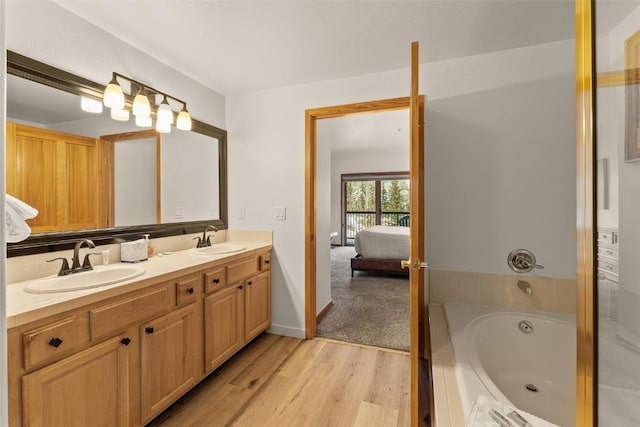 23110 US Highway 6 Unit 319, Keystone, CO 80435 - full bathroom featuring connected bathroom, double vanity, a bath, wood finished floors, and decorative backsplash