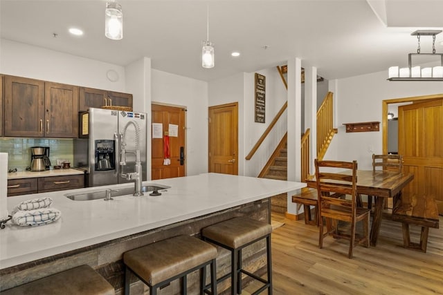 23110 US Highway 6 Unit 319, Keystone, CO 80435 - kitchen featuring stainless steel refrigerator with ice dispenser, decorative light fixtures, light wood-type flooring, a breakfast bar, and recessed lighting