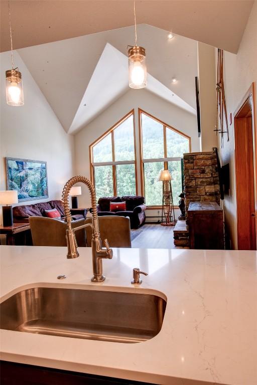 23110 US Highway 6 Unit 319, Keystone, CO 80435 - kitchen with open floor plan, hanging light fixtures, lofted ceiling, plenty of natural light, and wood finished floors