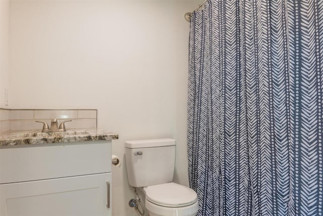 bathroom with toilet, vanity, and a shower with shower curtain