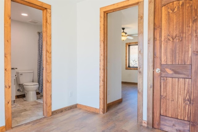 hallway with baseboards and wood finished floors