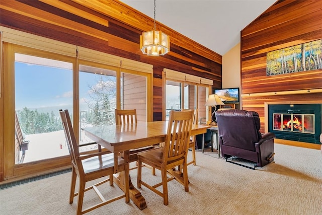 91200 Ryan Gulch Rd Unit 91223, Silverthorne, CO 80498 - carpeted dining area with wood walls, a chandelier, a glass covered fireplace, and high vaulted ceiling