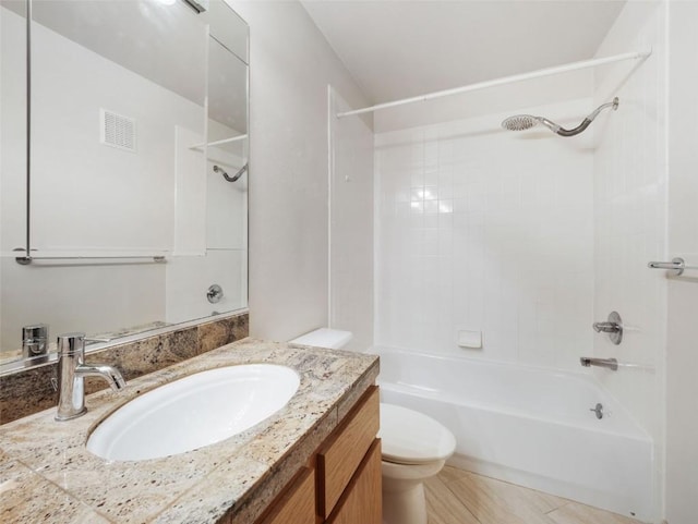 bathroom with visible vents, vanity, washtub / shower combination, and toilet