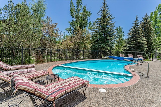 2700 Eagleridge Dr Unit N31, Steamboat Springs, CO 80487 - view of swimming pool with view of wooded area, a patio, and a pool with connected hot tub