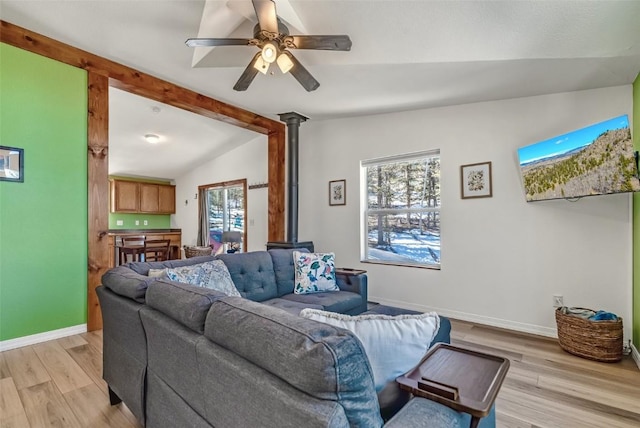 972 N Quarter Horse Rd, Jefferson, CO 80456 - living room featuring vaulted ceiling, a healthy amount of sunlight, a wood stove, and light wood-type flooring