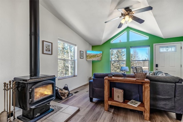972 N Quarter Horse Rd, Jefferson, CO 80456 - living room with visible vents, lofted ceiling, a ceiling fan, wood finished floors, and a wood stove