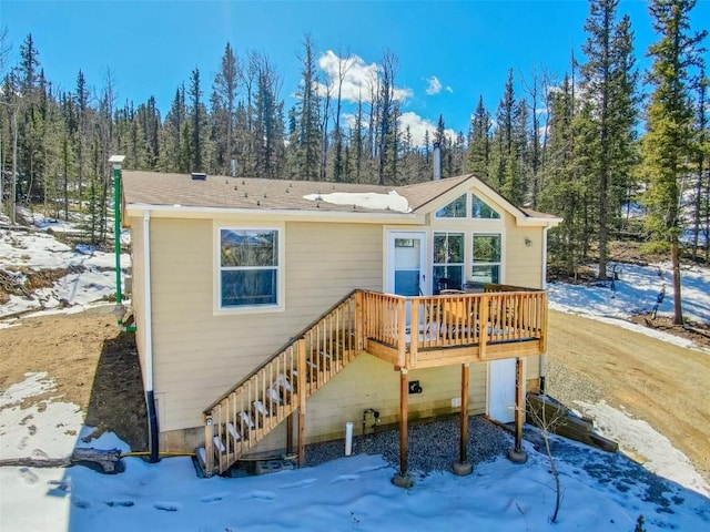 972 N Quarter Horse Rd, Jefferson, CO 80456 - snow covered house with a wooded view, a wooden deck, and stairs