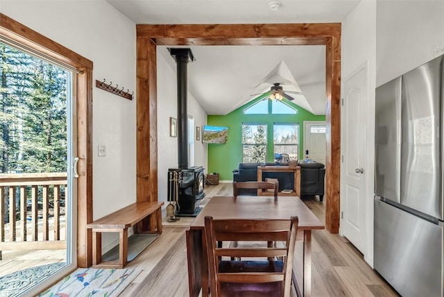 972 N Quarter Horse Rd, Jefferson, CO 80456 - dining room featuring a ceiling fan, vaulted ceiling, a wood stove, and light wood-style flooring