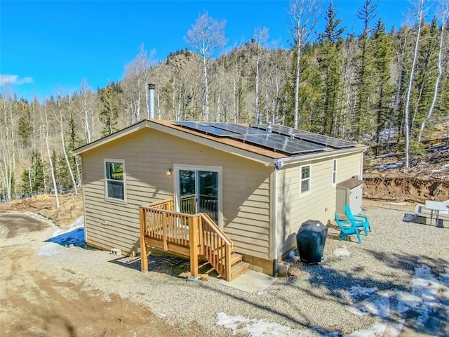 972 N Quarter Horse Rd, Jefferson, CO 80456 - rear view of house featuring a wooded view and solar panels