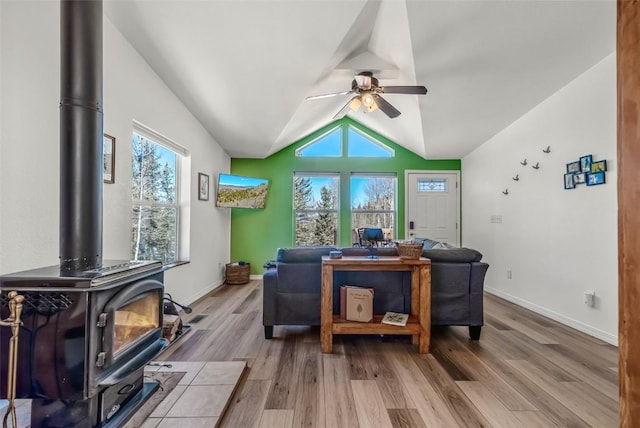 972 N Quarter Horse Rd, Jefferson, CO 80456 - living area featuring light wood-type flooring, ceiling fan, a wood stove, baseboards, and lofted ceiling