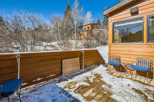 snow covered deck featuring fence