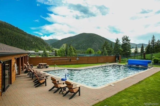 pool featuring a mountain view, fence, and a patio area