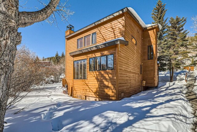 snow covered property featuring a chimney