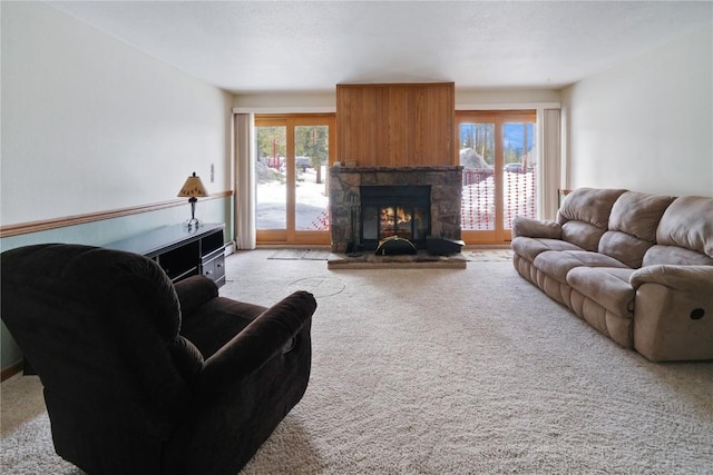 carpeted living area with a stone fireplace and a wealth of natural light