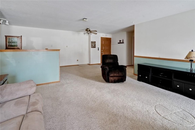 carpeted living room featuring baseboards and a ceiling fan