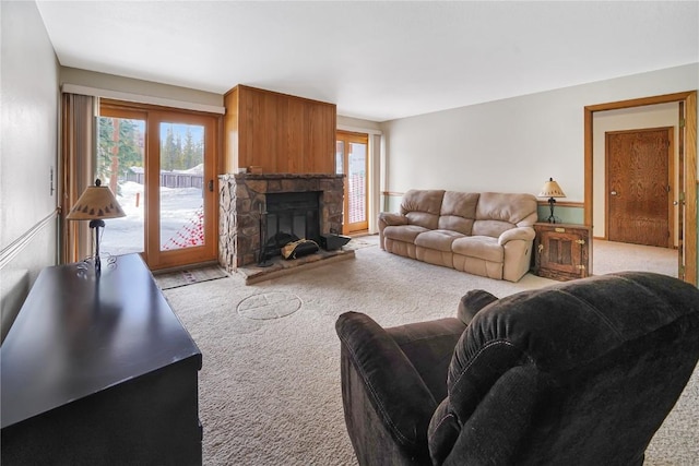 carpeted living area with a stone fireplace