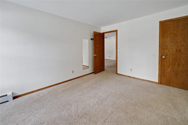 carpeted empty room featuring baseboards and baseboard heating